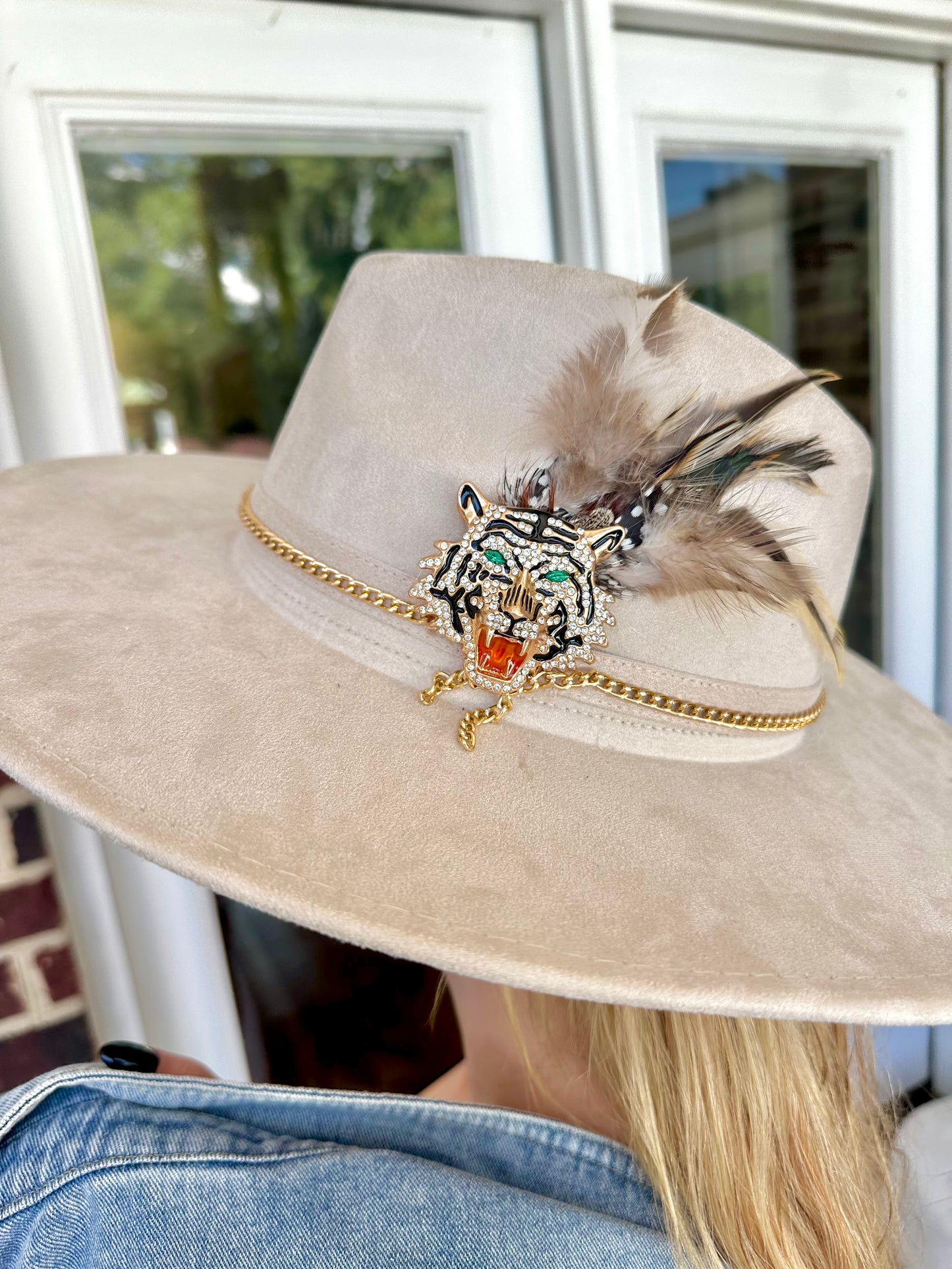 Close-up of cream Clemson Show Stopping Topper featuring a jeweled tiger centerpiece, gold chain trim and neutral feather accents.