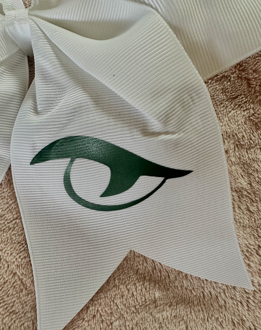Close-up of forest green matte Gator Eye vinyl logo on white grosgrain River Bluff cheer bow tail