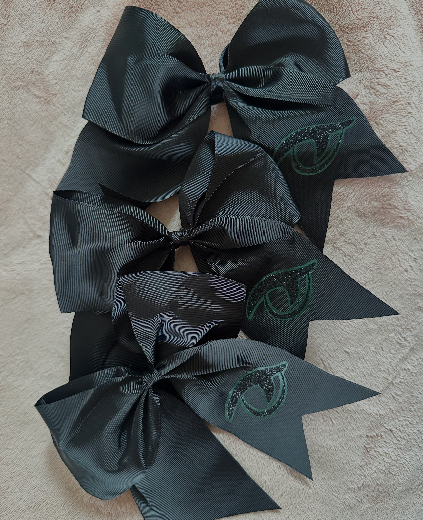 Multiple River Bluff black grosgrain Gator Eye cheer bows displayed together showing consistency