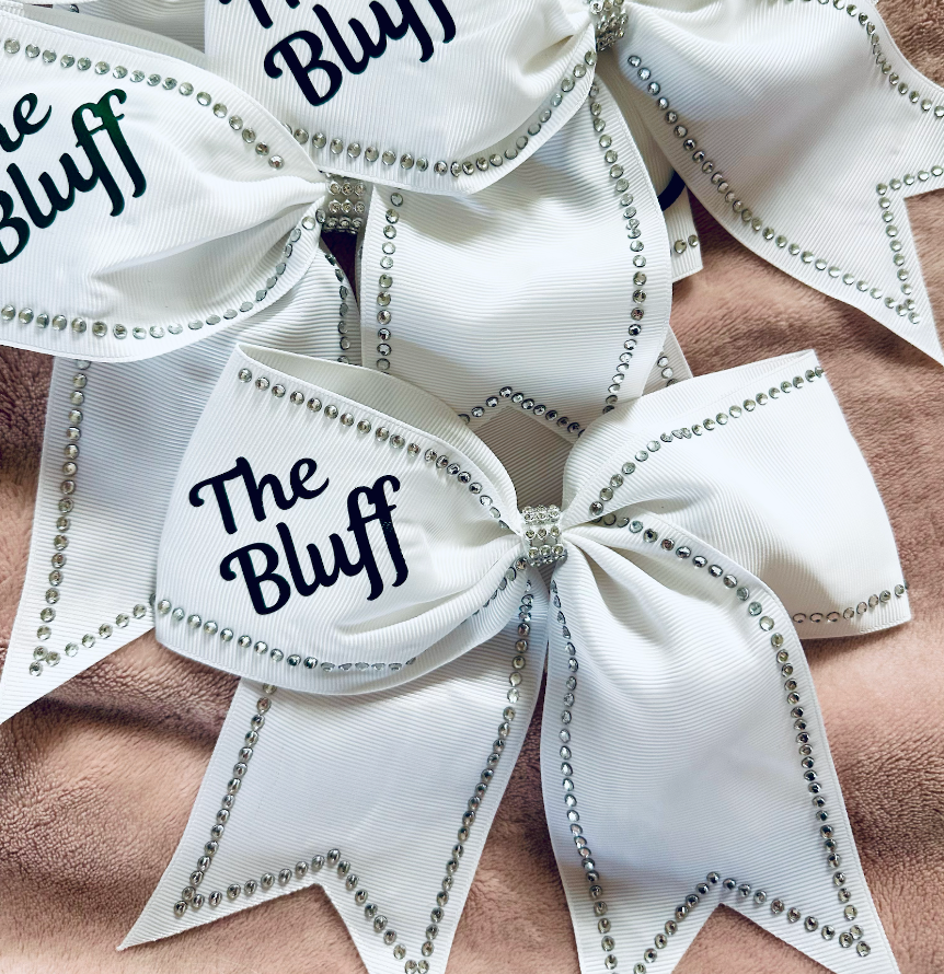 River Bluff white grosgrain cheer bow with silver rhinestone trim and forest green The Bluff lettering – front view