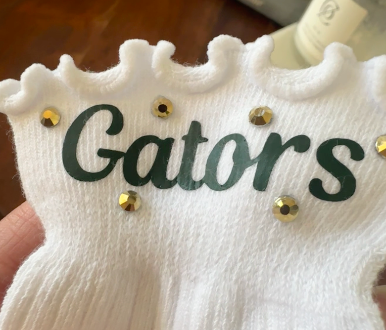 White frilly ankle sock with forest green Gators lettering and gold rhinestone accents – River Bluff girls spirit wear by Southern Script