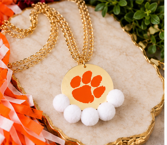 Clemson Paw Pom Statement Necklace with orange paw design on a gold-tone round pendant, white pom-pom trim and gold-tone chain.