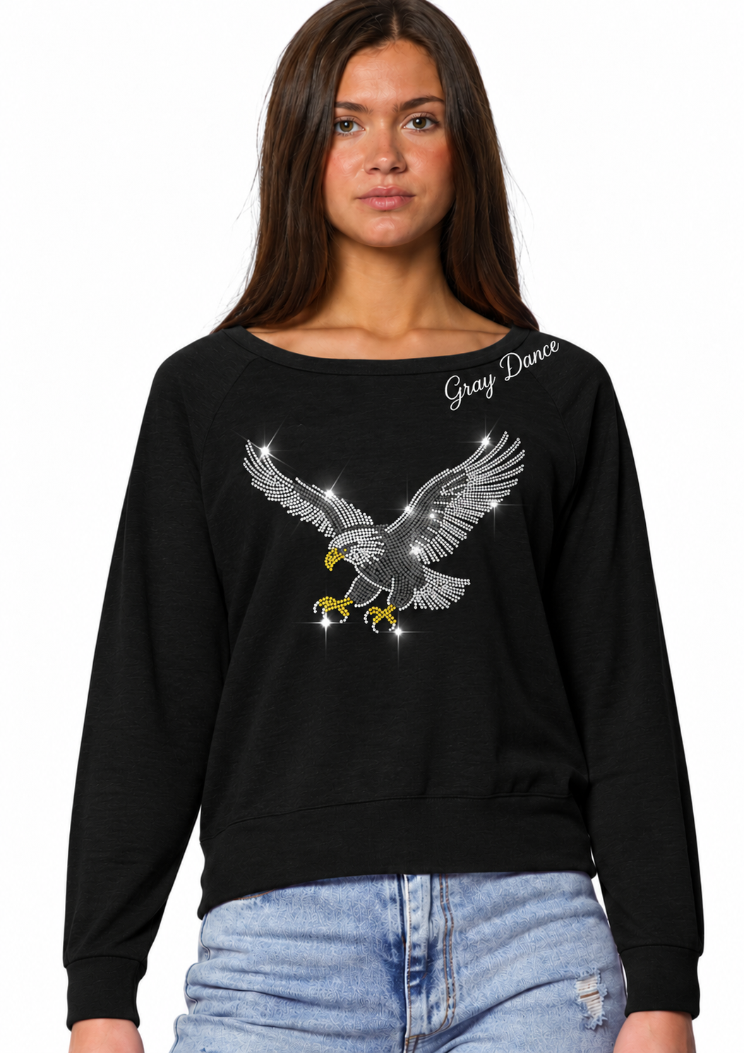 A woman wearing a black crewneck sweatshirt with a large gray and yellow eagle graphic on the front, paired with light blue jeans, against a plain white background.Woman wearing black Gray Dance Spotlight Pullover with white script neckline and sparkling silver, white and gold rhinestone eagle