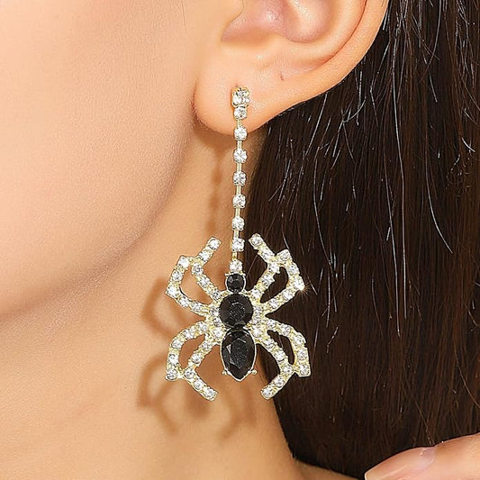 Model wearing a black rhinestone spider drop earring with a gold-tone setting